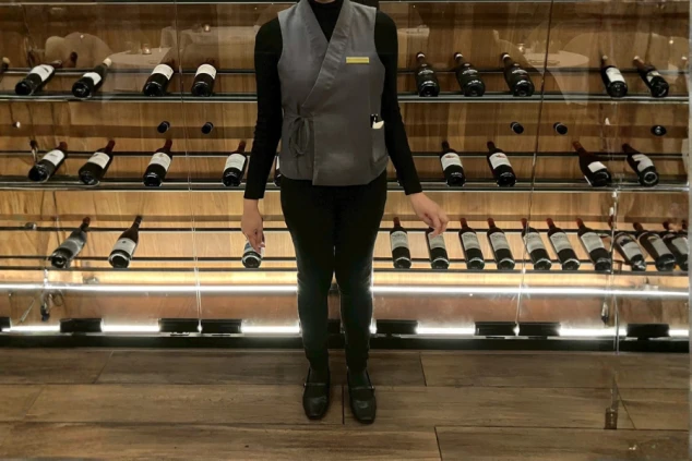 グレーのモダンな和風ベストと黒い服を組み合わせた、ホテルの接客スタッフの制服。