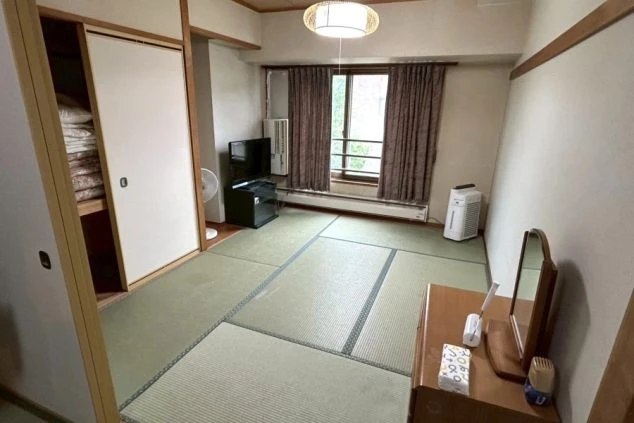 リゾートバイトの個室寮の和室。畳敷きの部屋にテレビ、加湿器、ドレッサーなどが備え付けられ、仕事の後にくつろげるプライベート空間。