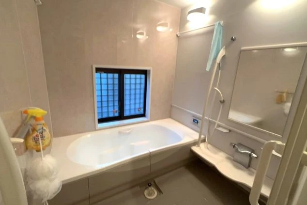 リゾートバイトの女子寮のバスルームの画像。広々とした浴槽とシャワーがあり、壁はタイル張りで清潔感がある。窓も付いており、リラックスして入浴できる寮の設備。