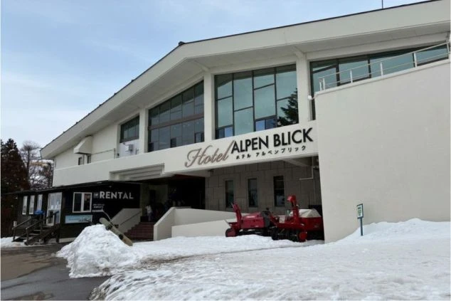 冬の「ホテル アルペンブリック」の外観。雪景色の中に立つ、大きな窓が特徴的なリゾートホテル。