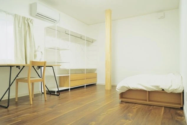 白を基調とした香川県直島町の女性寮の個室。ベッド、デスク、収納スペースが備え付けられ、リゾートバイトに集中できるプライベート空間です。