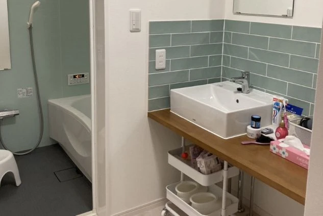 ワクトリの社員が出張で撮影した、女性寮のバスルームの画像。淡いミントグリーンのタイルがアクセントになった洗面台と、清潔感のある浴槽が備わっている。機能的で整頓された水回り設備。