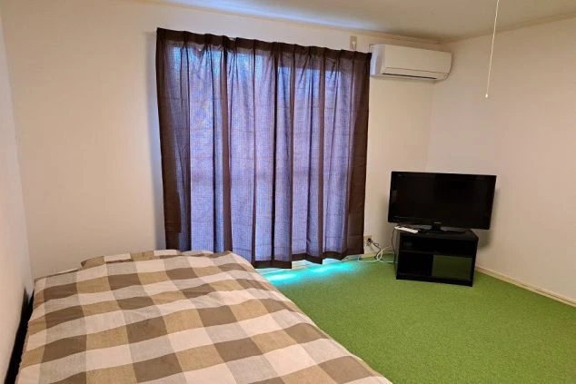 寮の個室。ベッドとテレビ、エアコン付き。