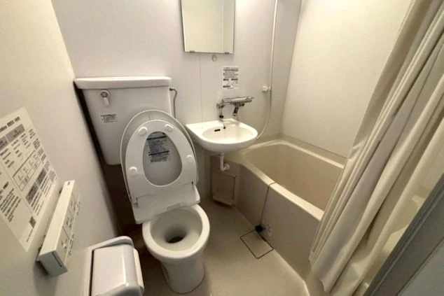 リゾートバイトの寮に備え付けられた、ユニットバスの画像。便座と洗面台、バスタブがまとまって配置されている。清潔感のある、寮の風呂場の画像。