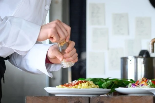 彩り豊かな和食膳の盛り付けを行う調理補助の仕事。衛生管理を徹底した厨房で、お客様へ提供する一皿を丁寧に仕上げるリゾートバイトの業務風景の画像。