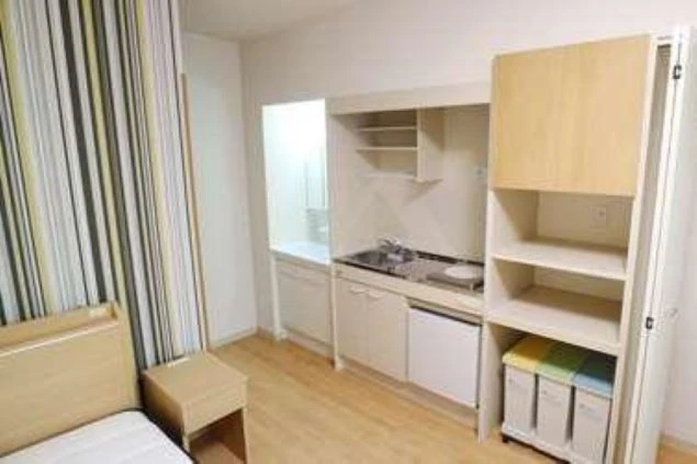 リゾートバイトの個室寮の個室内にあるシステムキッチン画像。ゴミ箱や収納棚なども充実している。