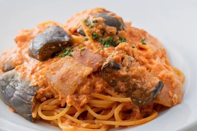 看板メニューの茄子とベーコンのトマトクリームパスタが白い皿に盛り付けられた料理のイメージ画像。軽井沢のおしゃれなイタリアンで提供される食事。