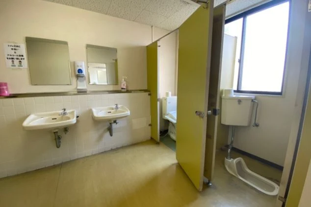 リゾートバイトの社員寮にある共用トイレのイメージ画像。鏡と複数の洗面台が並んでいる。