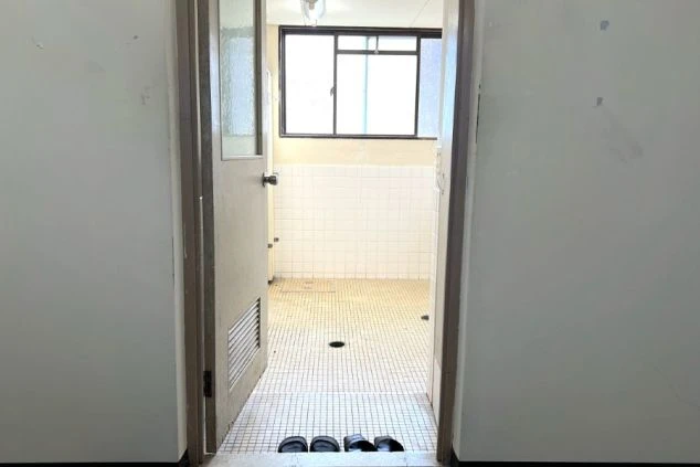 スタッフ寮にある、清潔なタイル張りの水回りスペース。窓から光が差し込む明るい空間。