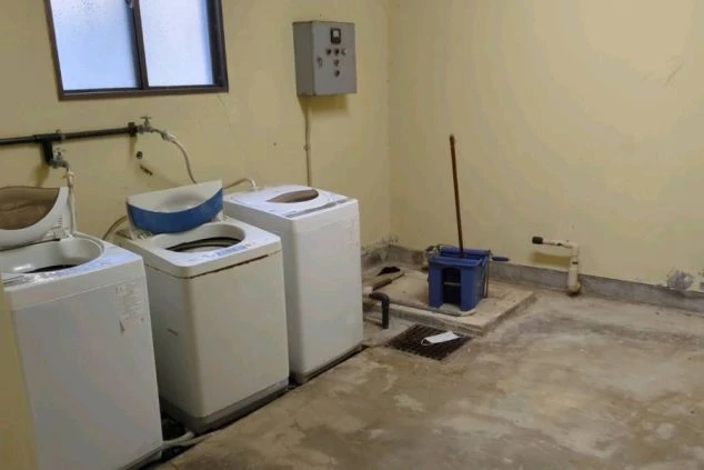 山口県下関のリゾートバイトの寮に完備された、スタッフ共用で無料使用可能な洗濯機スペース。長期滞在でも衣類の心配がなく、快適な寮生活を送れます。