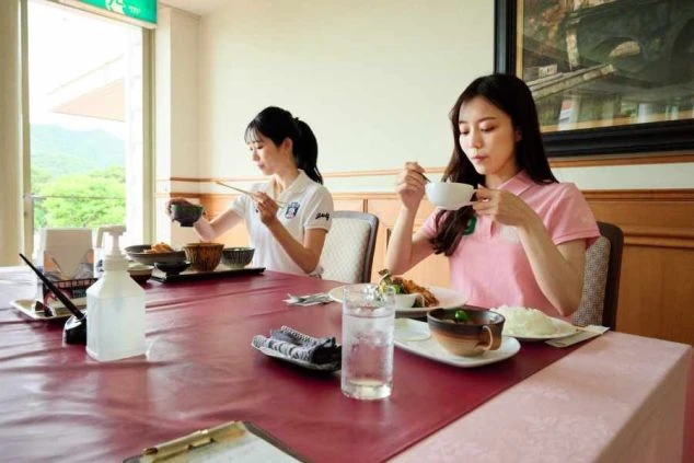 ゴルフ場レストランで女性が食事をする様子の画像