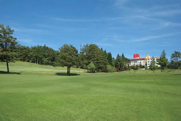 広々とした緑色のゴルフコースが手前に広がり、奥には木々に囲まれた赤い屋根の鷲ヶ岳のホテルが見える画像。リゾートバイトでゴルフ場やホテルで働く、開放的な環境のイメージ。