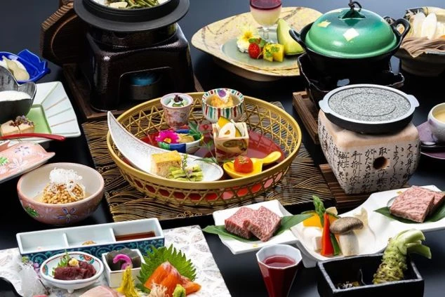 ホテルで提供される豪華な日本料理の数々。彩り豊かな前菜、新鮮な刺身、美しい盛り付けの肉料理などが並ぶ食卓。