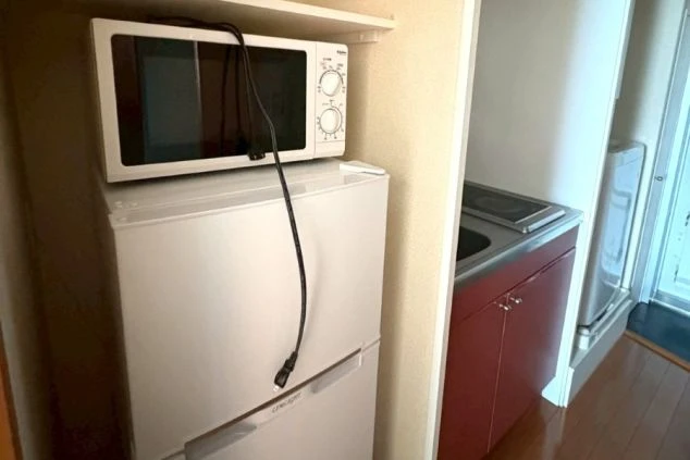 リゾートバイト個室寮の室内キッチン。電子レンジや冷蔵庫が備え付けられ、すぐに自炊を始められる環境。