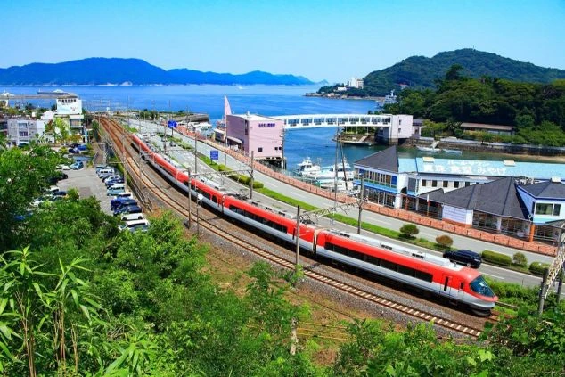 晴れた日の三重県の海沿いを走る電車の画像