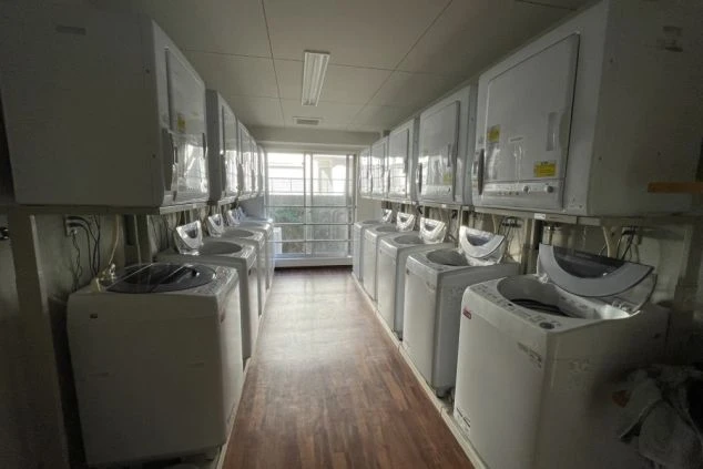 リゾートバイト寮の共同ランドリールーム。洗濯機と乾燥機が多数設置されており、いつでも気兼ねなく洗濯ができます。