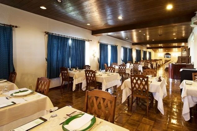 リゾートホテルのレストラン。テーブルと椅子が並び、食事の準備が整った職場のイメージ画像。