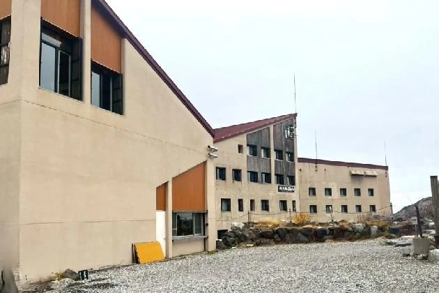 茶色とベージュの外壁を持つ、山岳地帯にある傾斜の屋根が特徴的な数階建ての宿泊施設。