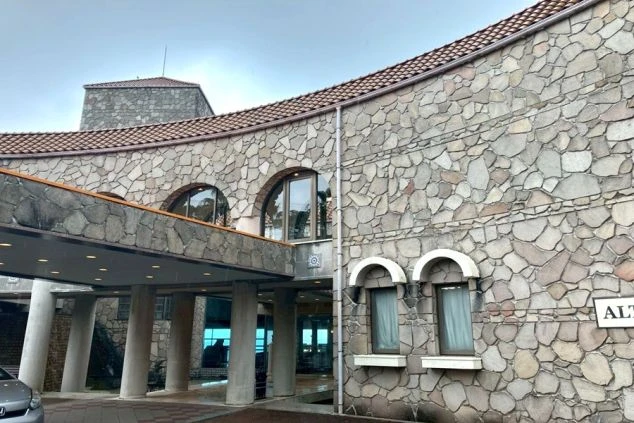 ヨーロッパの古城のような雰囲気のホテルエントランス。外壁は不揃いの石積みが特徴で、丸みを帯びた屋根とアーチ型の窓がある。