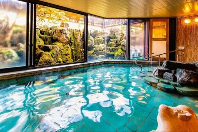 リゾートバイトの就業先のホテルの大浴場の画像。窓からは滝を見ることができ、スタッフは無料で入ることが可能。