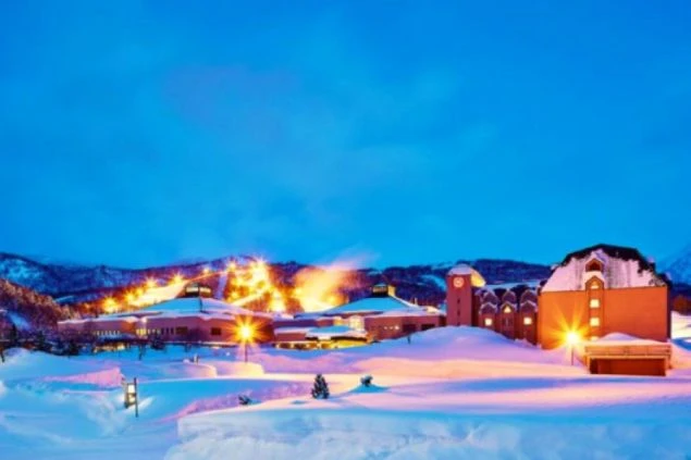 雪に覆われたキロロスノーワールドの夜景の画像。ライトアップされたホテルや山肌の明かりが幻想的な雰囲気を醸し出す、冬のロマンチックな光景。