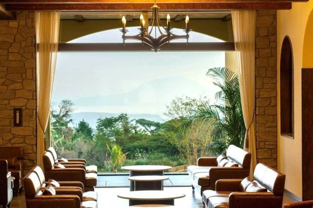 リゾートバイトの就業先ホテルのロビーの画像。。中央の大きな窓からは、鹿児島湾に浮かぶ桜島や南国を思わせる草木が見えている。