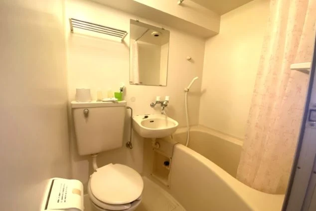 リゾートバイトの寮のユニットバス形式のバスルームの画像。トイレ、洗面台、浴槽がコンパクトにまとまっており、清潔感が保たれている。