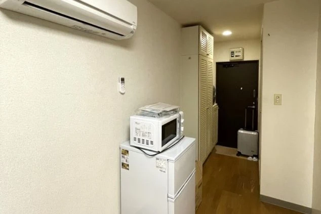 リゾートバイトの個室寮の部屋の画像。冷蔵庫と電子レンジとエアコンが見える。