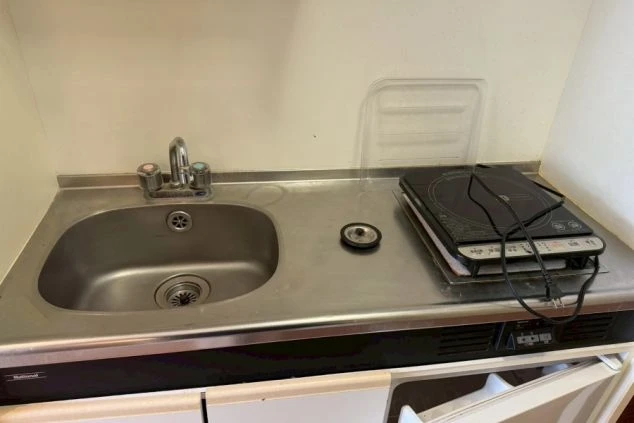 寮のミニキッチン。IHコンロとシンクが備え付けられており、自炊で食費を節約したい方におすすめ。