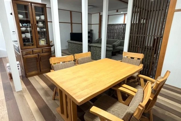 寮の食堂。大きなダイニングテーブルと椅子、食器棚が並ぶ空間。