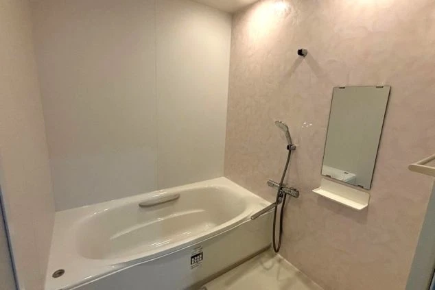 寮のお風呂。浴槽とシャワー、鏡、タオル掛けが設置され清潔。