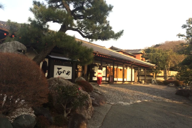 見事な松の木と石組みの庭園が配置され、情緒漂う瓦屋根の和風建築が夕暮れ時に美しく佇んでいます。