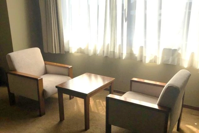 日当たりの良い広縁。2脚の肘掛け椅子とサイドテーブルが窓際に置かれている。