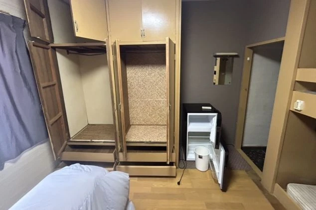 リゾートバイトの寮の部屋の画像。部屋には二段ベッドのような形のベッドと、冷蔵庫、クローゼットが備え付けられている。リゾートバイトの寮の部屋の画像。