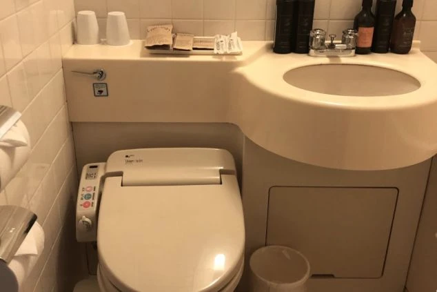 リゾートバイトの寮のユニットバスの画像。便座、洗面台、バスタブがまとまって配置されている。清潔感のある、寮の風呂場の画像。