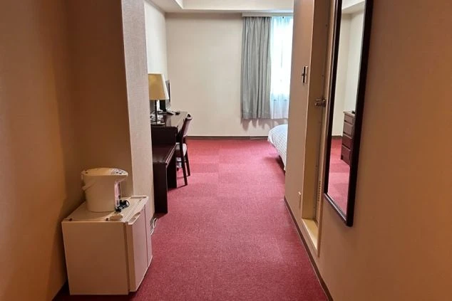 リゾートバイトの客室寮の広々とした室内。ミニ冷蔵庫と電気ケトルも完備されており、長期滞在でも不自由なく生活できます。プライベート重視の方に最適な個室寮のリゾートバイト。