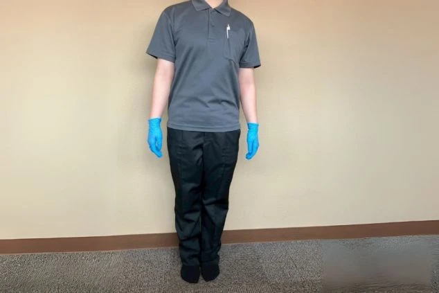 客室清掃の制服画像。動きやすいポロシャツに黒いズボンを着用。