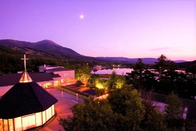 夕焼け空の下、湖が映るリゾート施設の夜景のイメージ画像。リゾートバイトの休日を満喫。