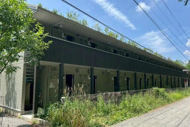 リゾートバイトの寮の外観を撮影した画像。1階と2階の部屋が並んでおり、壁にはツタが生い茂っている。リゾートバイトの寮の外観の画像。