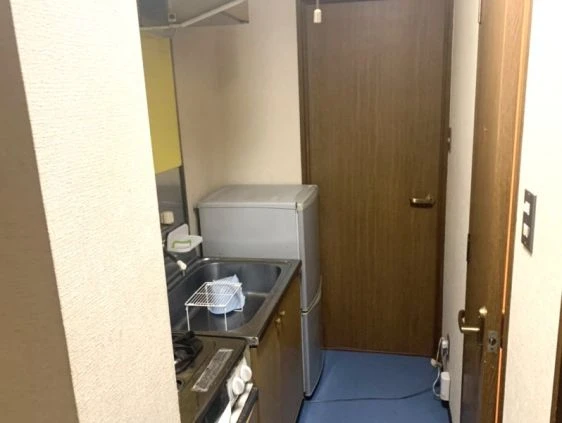 リゾートバイト寮の共用キッチン。ガスコンロと冷蔵庫が完備されており、自炊に便利な寮画像。