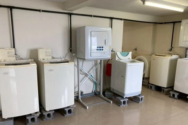 リゾートバイトの個室寮の共用洗濯機・乾燥機の画像。