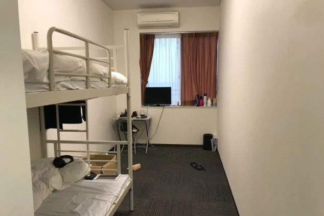 リゾートバイトの館内寮にある個室の室内。二段ベッドとデスク、テレビが備え付けられ、快適に過ごせる空間の画像。