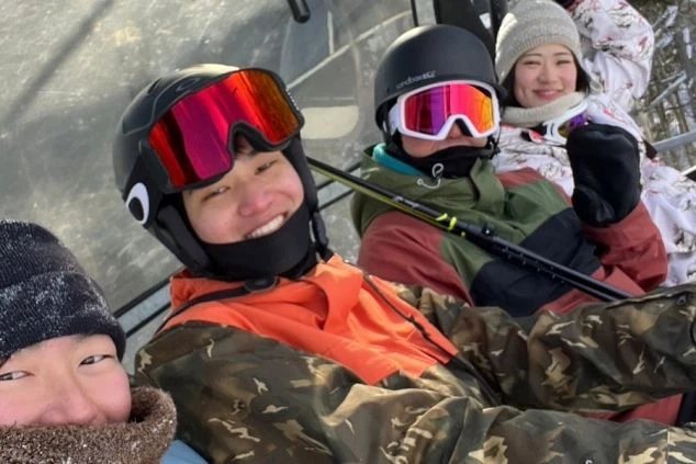 スキー場でリフトに乗って笑顔でポーズをとる若者たち。冬のリゾートバイトの休日の過ごし方のイメージ。