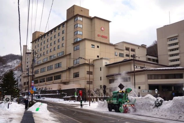 リゾートバイトの勤務先ホテルの売店の画像。赤い提灯が飾られ和風の建物には「Japan Tax-free Shop」の表示があり、浴衣姿の人が歩いている。