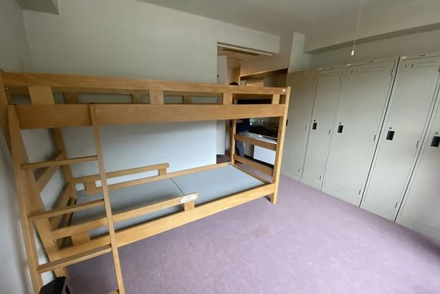 寮の相部屋。二段ベッドとロッカーが映る。