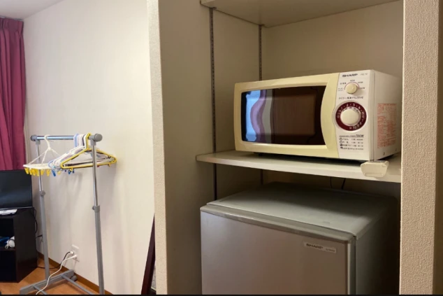 寮の部屋に備え付けられた冷蔵庫と電子レンジ。生活に必要な家電が揃っている。