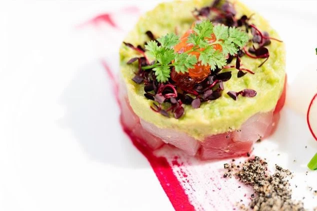 リゾートバイト先ホテルレストランで提供されている前菜料理。彩り鮮やかなソースとハーブで飾られている。