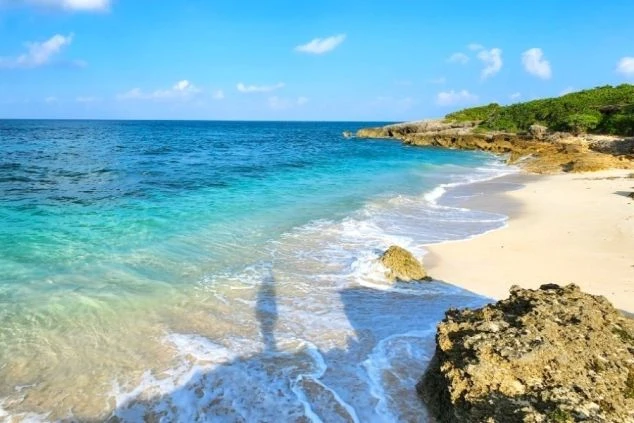 白い砂浜と透明度の高いエメラルドグリーンの海が広がる宮古島のビーチ。波打ち際が美しく、沖縄の離島でのリゾートバイトで、海辺での仕事やマリンアクティビティに興味がある方に最適な画像。