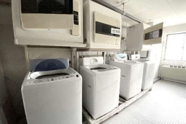 リゾートバイト寮のランドリースペース。洗濯機と乾燥機が複数台完備されており、いつでも自由に洗濯ができる、共同利用の設備の画像。