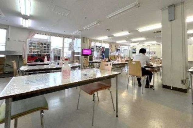 リゾートバイト寮の広々とした食堂。テーブルと椅子が多数並べられ、食事ができるだけでなく、休憩や交流にも利用できる共用スペースの画像。